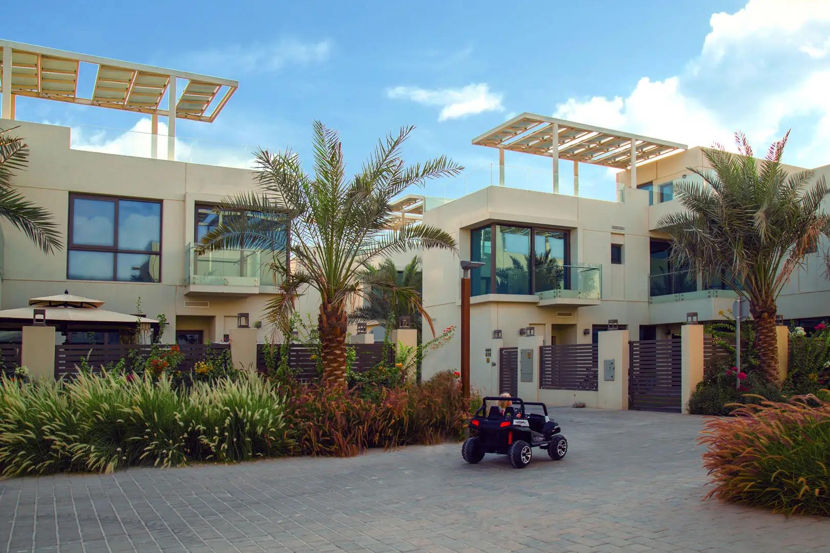 A child cycling past villas with rooftop solar